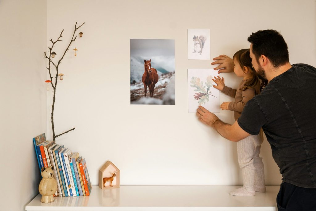 un homme et une petite fille regardant des images sur un mur